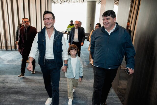 Caicedo y Alarcón caminando de la mano de un niño