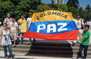 Colombia frente a una violencia persistente: entre el discurso de paz y la realidad territorial Bandera de Colombia, con la palabra PAZ, 6 personas sosteniendo la bandera