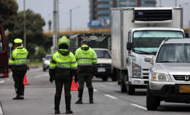 Reten policial, vehículos, conos, 3 policías para el pico y placa